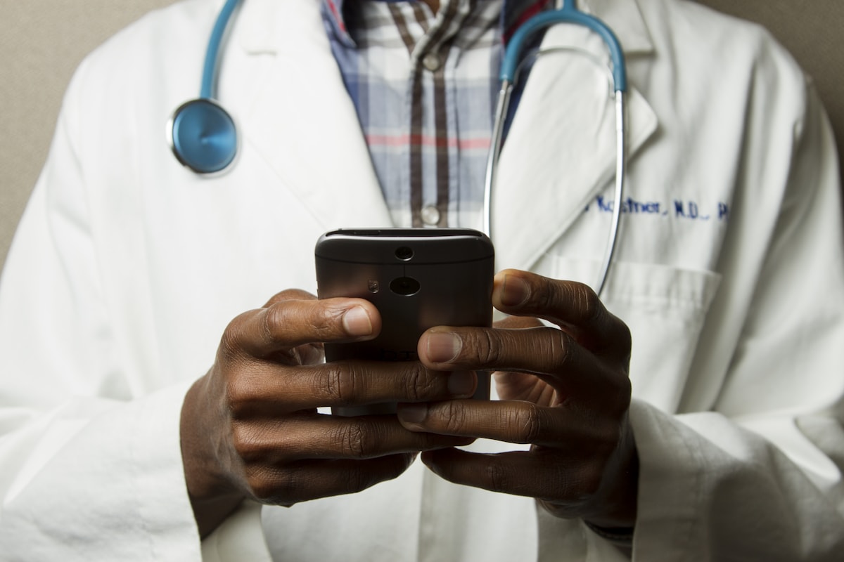 Profissional de saúde usando o celular em seu consultório